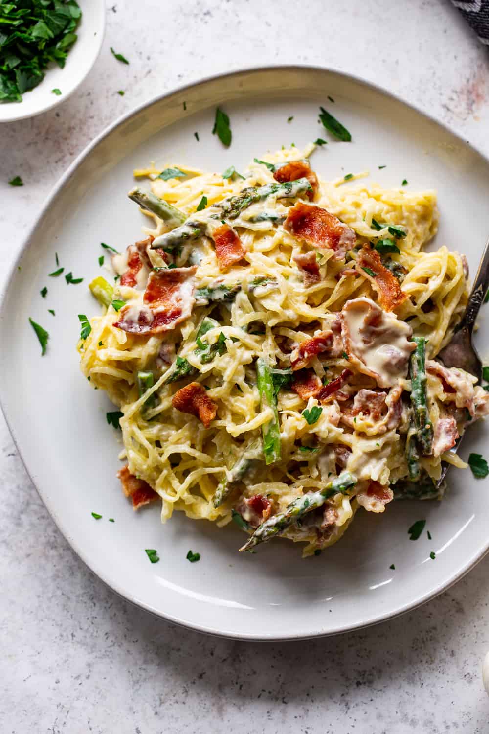 This roasted garlic spaghetti squash has a creamy savory sauce with crispy bacon plus sautéed asparagus. It’s flavor packed, low in carbs, paleo and Whole30 friendly. #paleo #whole30 #keto #lowcarb #cleaneating