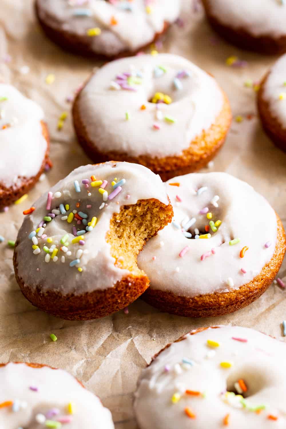 These paleo vanilla frosted donuts are a huge treat and easy to make, too! Healthy gluten free and dairy free baked donuts are dipped in a creamy vanilla frosting for a fun treat everyone will love. If you don't have a donut pan, make them into cupcakes! #paleo #cleaneating #glutenfree