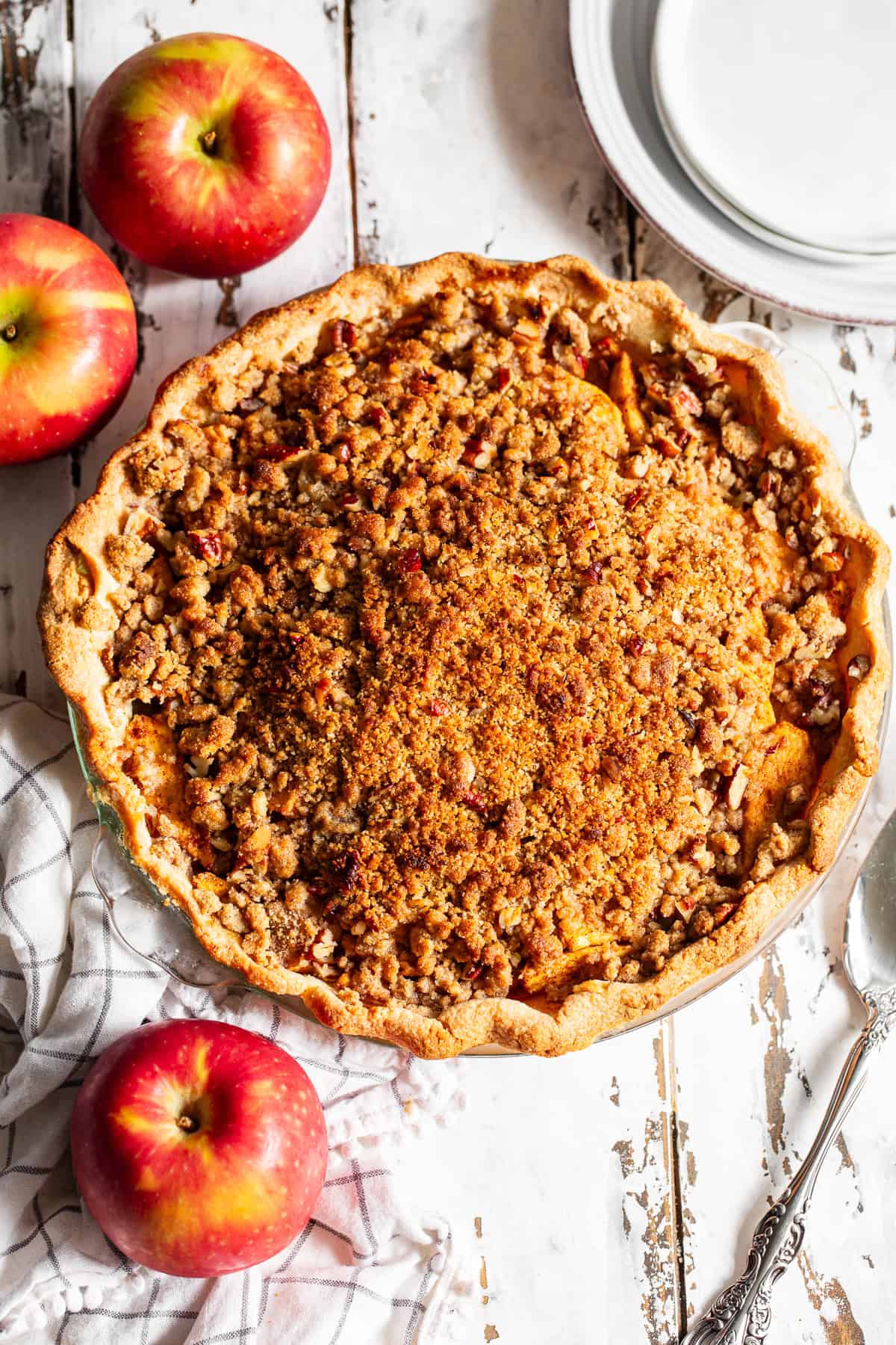 Overhead view of homemade apple crumble pie with golden crumb topping.