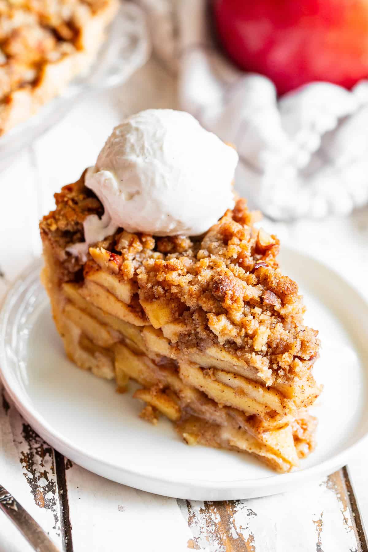 Warm apple crumble pie topped with a scoop of vanilla ice cream.