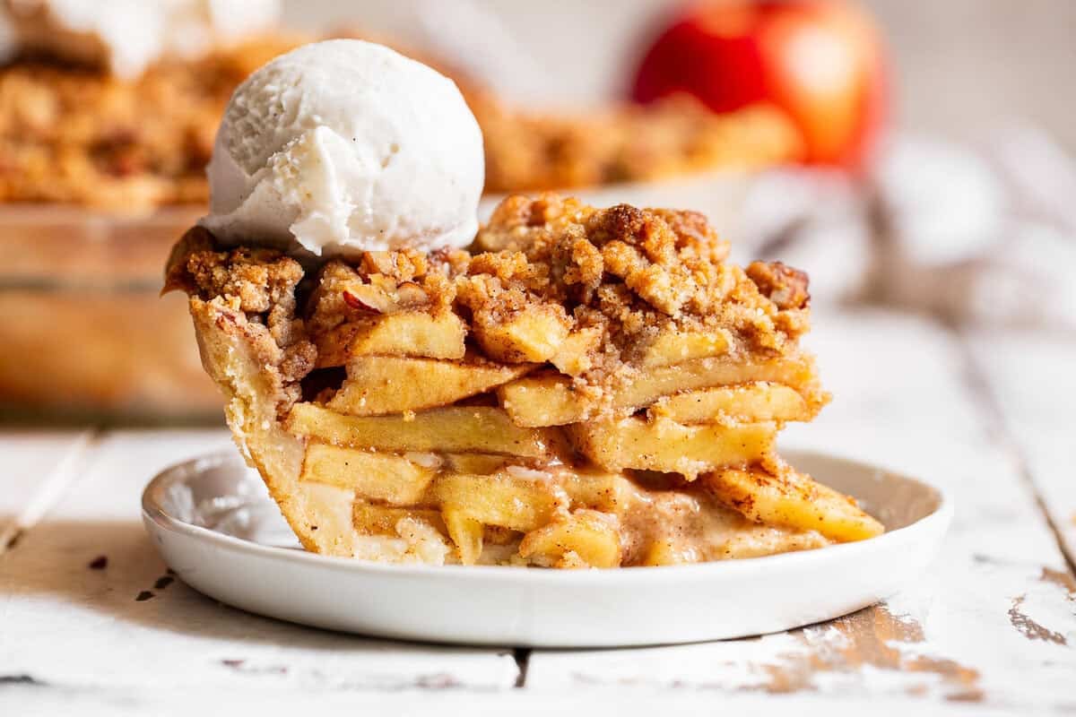 Warm apple crumble pie topped with a scoop of vanilla ice cream.