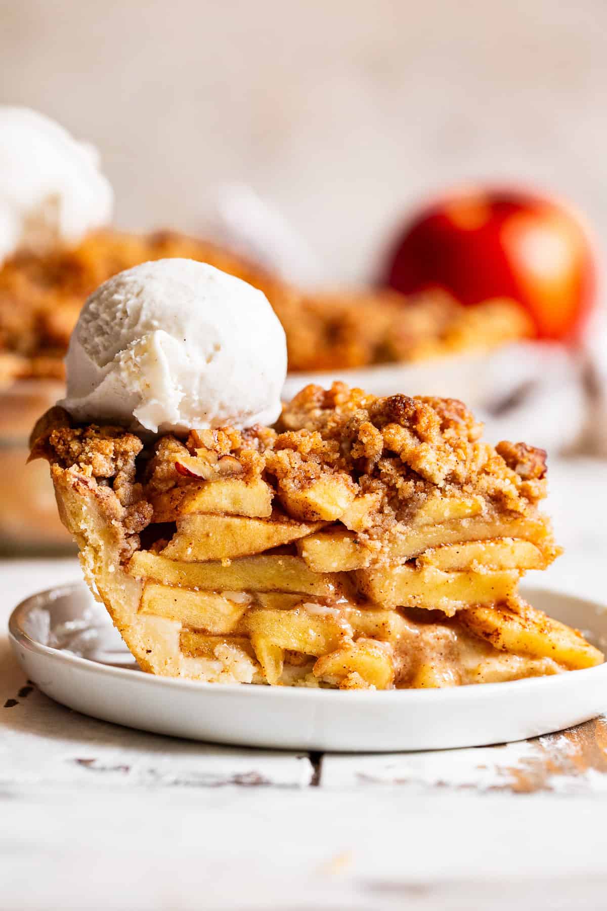 Warm apple crumble pie topped with a scoop of vanilla ice cream.