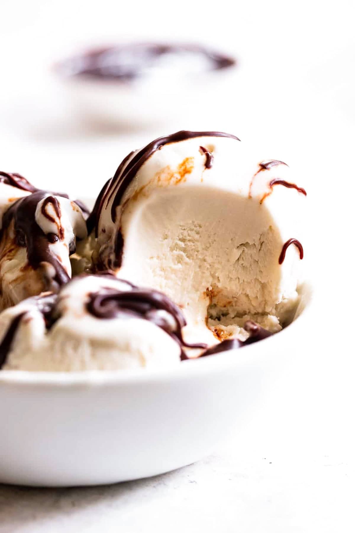 paleo vanilla ice cream in a bowl with chocolate syrup