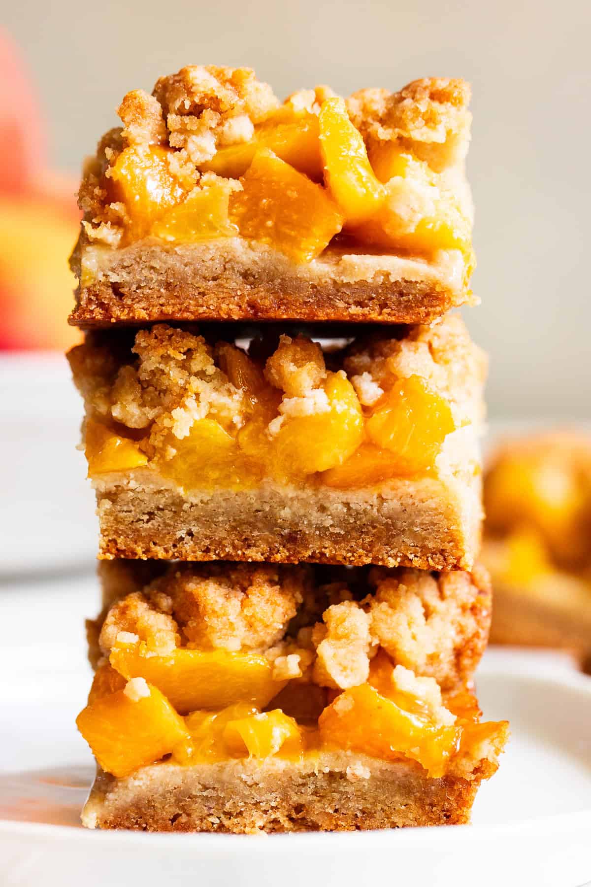 Stacked peach crumble bars with almond flour crust and fresh peach filling