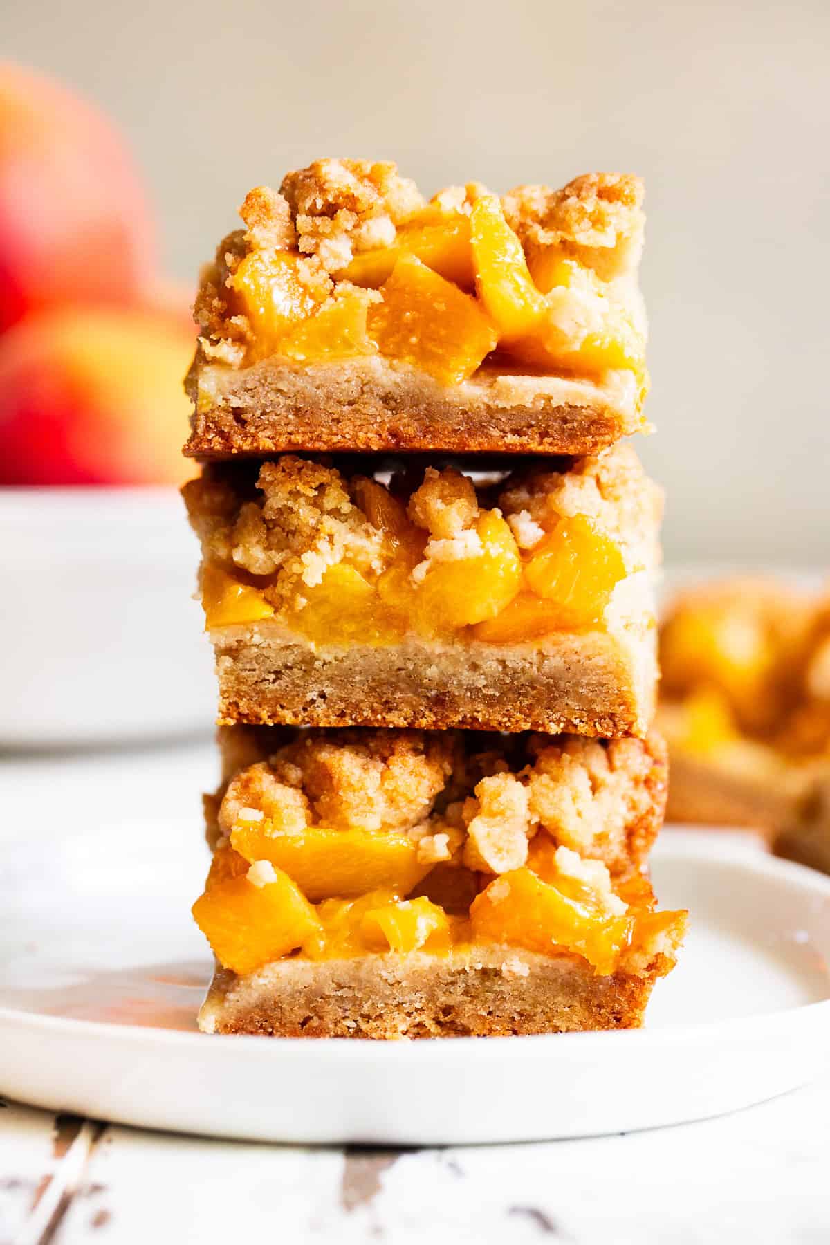 Stacked peach crumble bars with almond flour crust and fresh peach filling