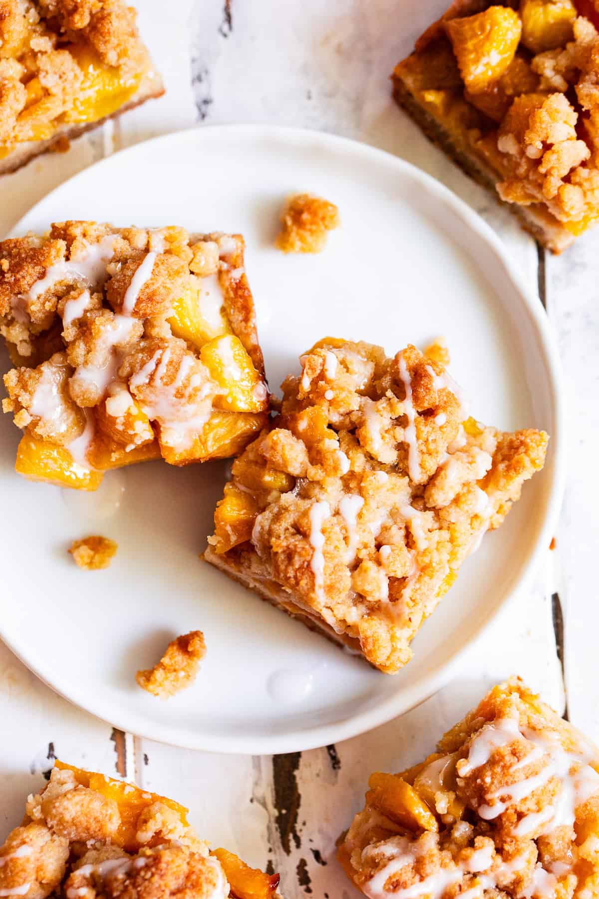 Peach crumble bar with buttery almond flour crust and golden crumb topping