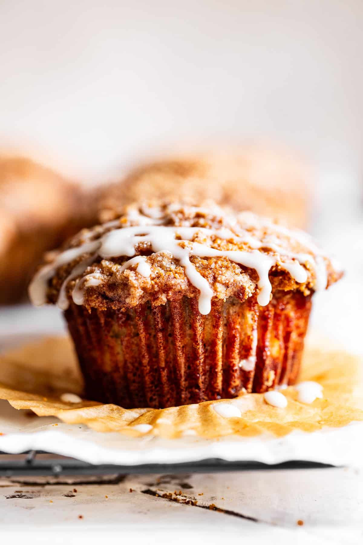 Apple crumb muffins with cinnamon crumb topping and a light vanilla glaze.