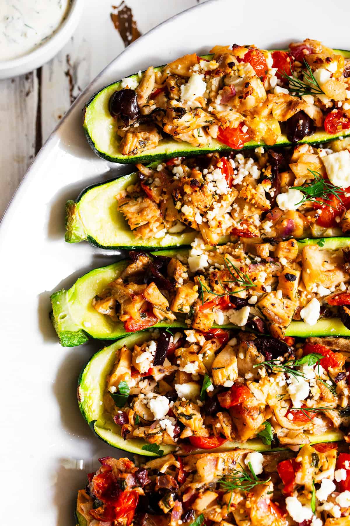Greek chicken zucchini boats with rotisserie chicken, tomatoes, olives, feta