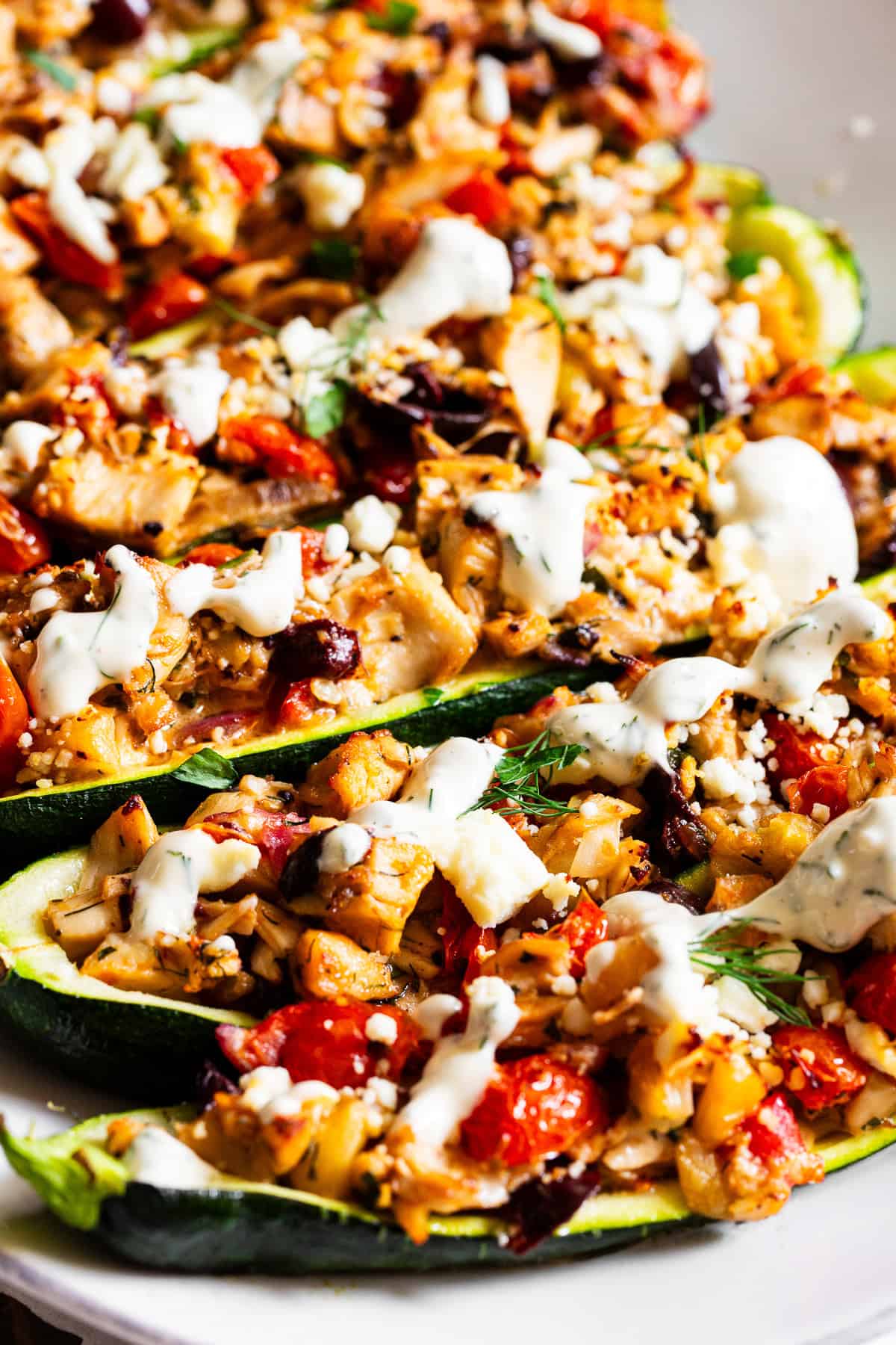 Greek chicken zucchini boats with rotisserie chicken, tomatoes, olives, feta and lemon dill sauce