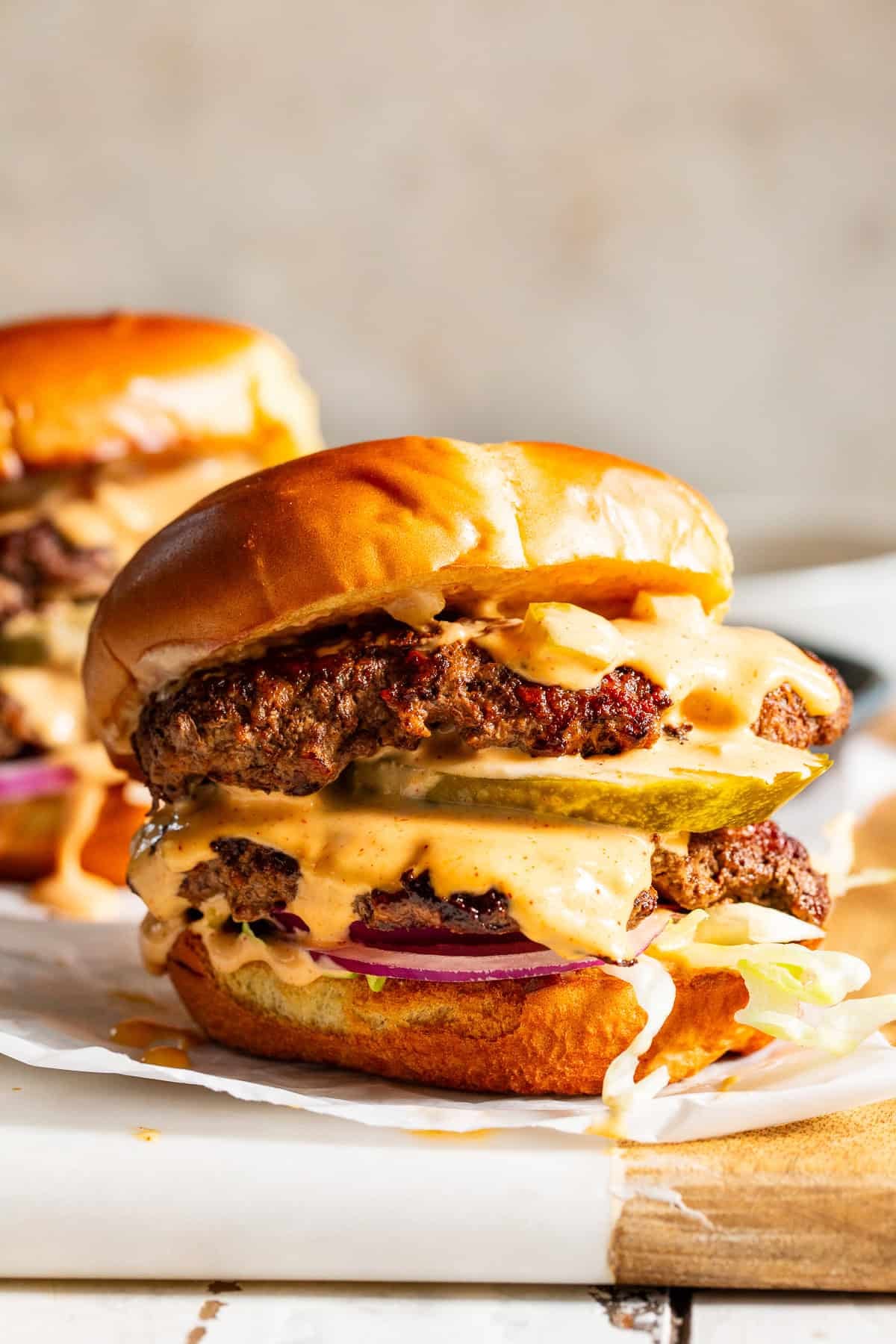 Double smash burger with crispy beef patties, pickles, onions and creamy burger sauce on a toasted bun.