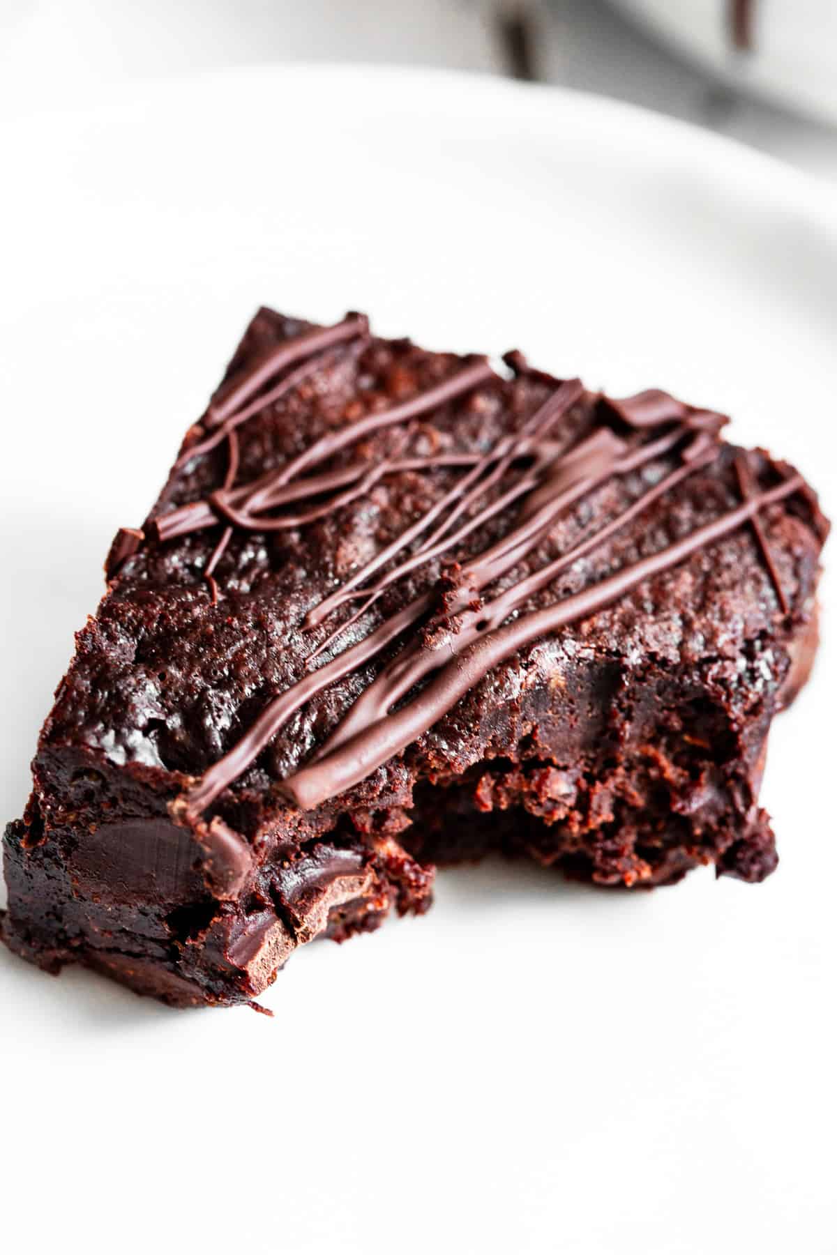 Fudgy healthy zucchini brownie broken in half with melted chocolate chips