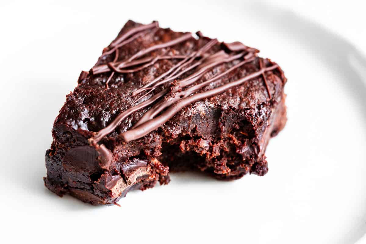 Fudgy healthy zucchini brownie broken in half with melted chocolate chips