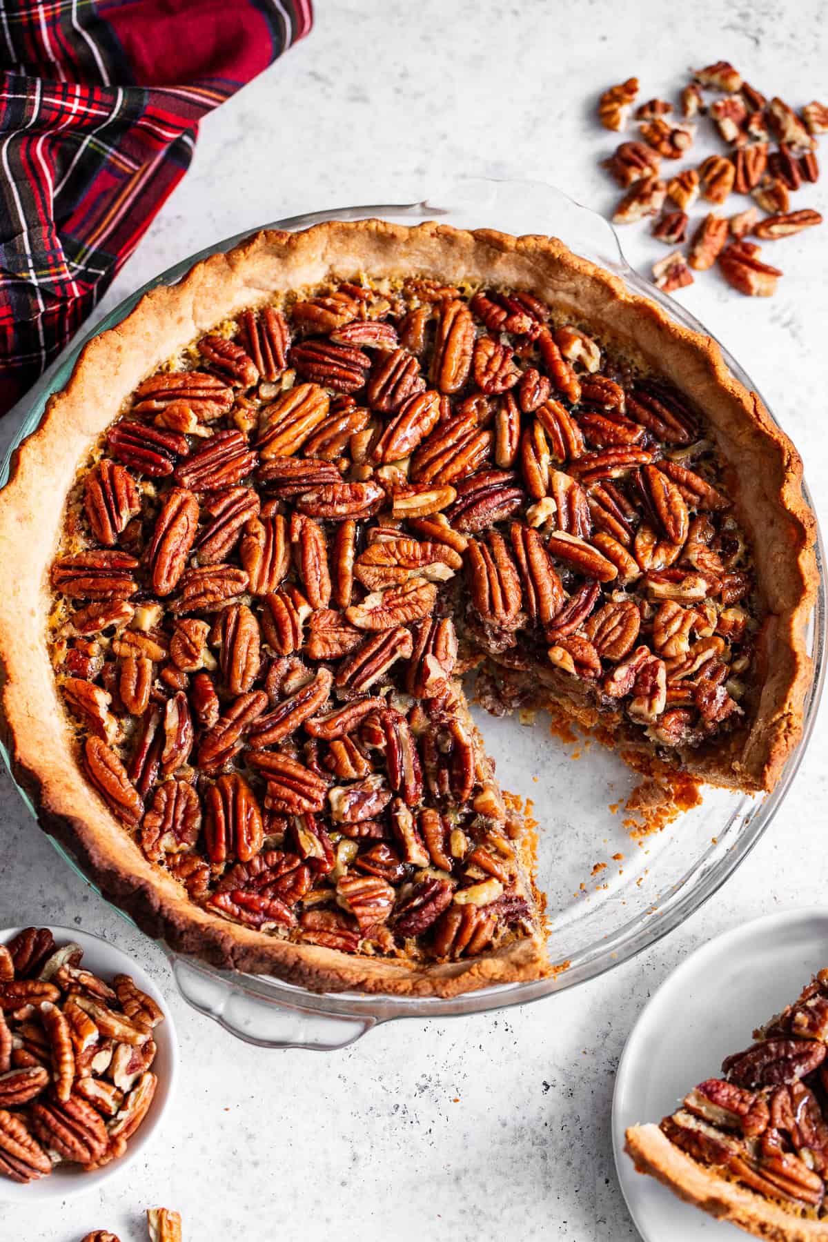 Pecan pie with a golden grain-free crust in a glass pie plate.