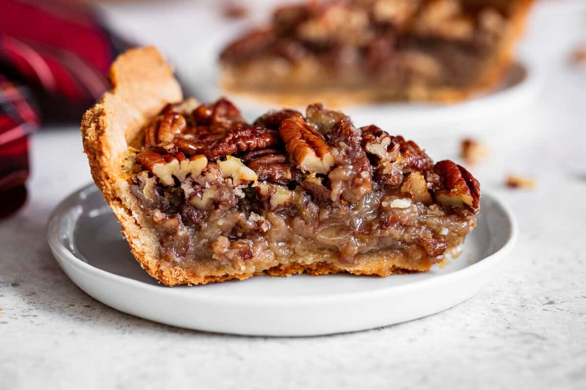 Slice of paleo pecan pie with maple filling on a white plate.