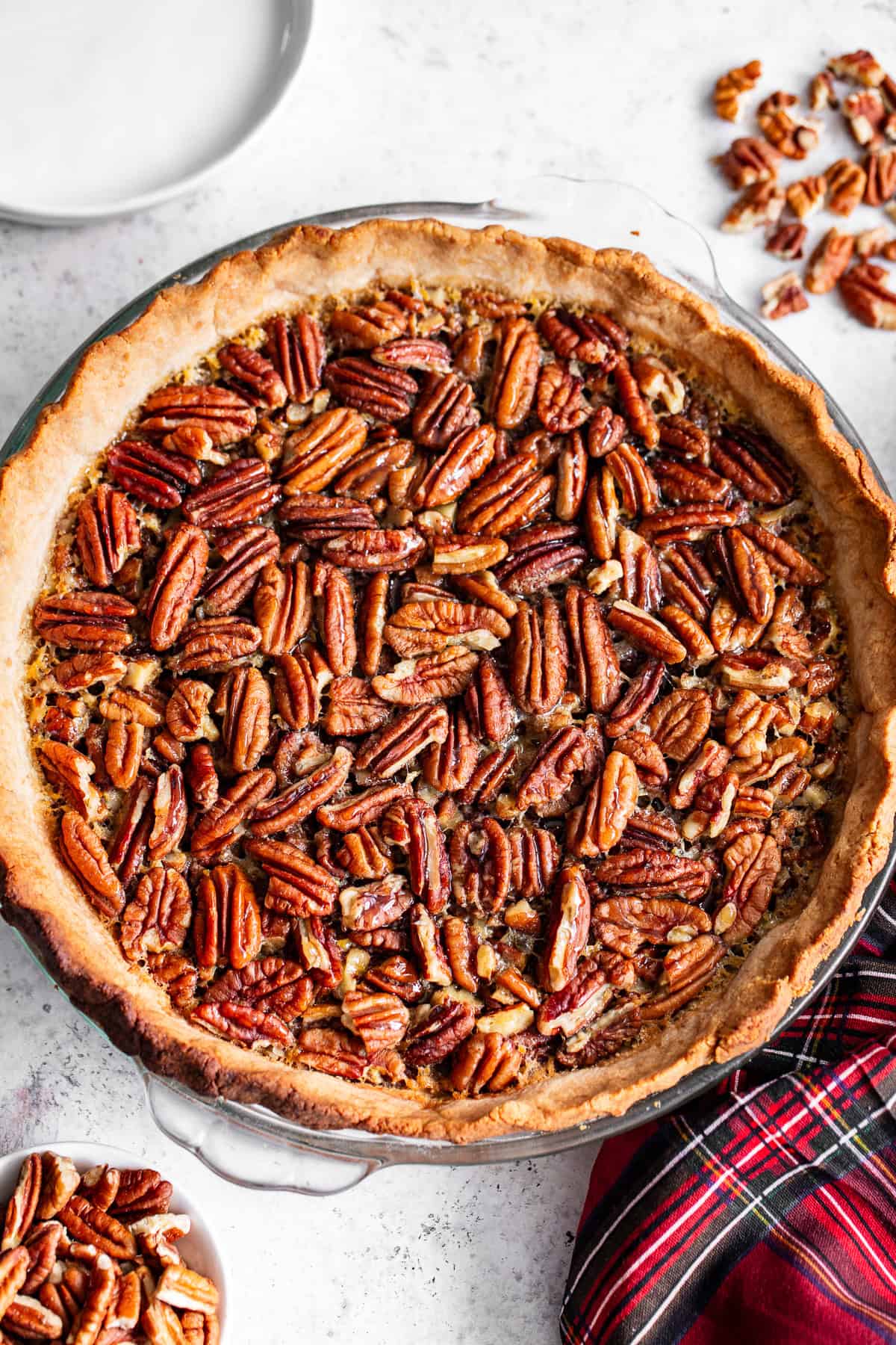 Pecan pie with a golden grain-free crust in a glass pie plate.
