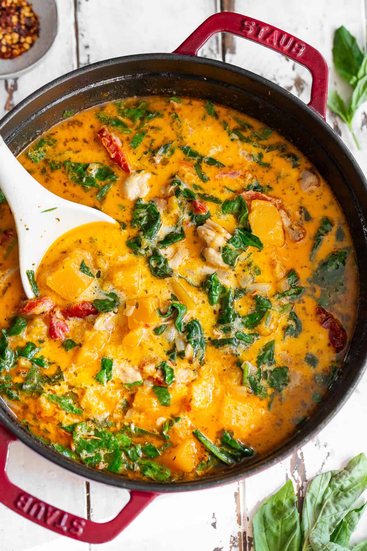 overhead shot of creamy tuscan chicken butternut squash soup in a red dutch oven