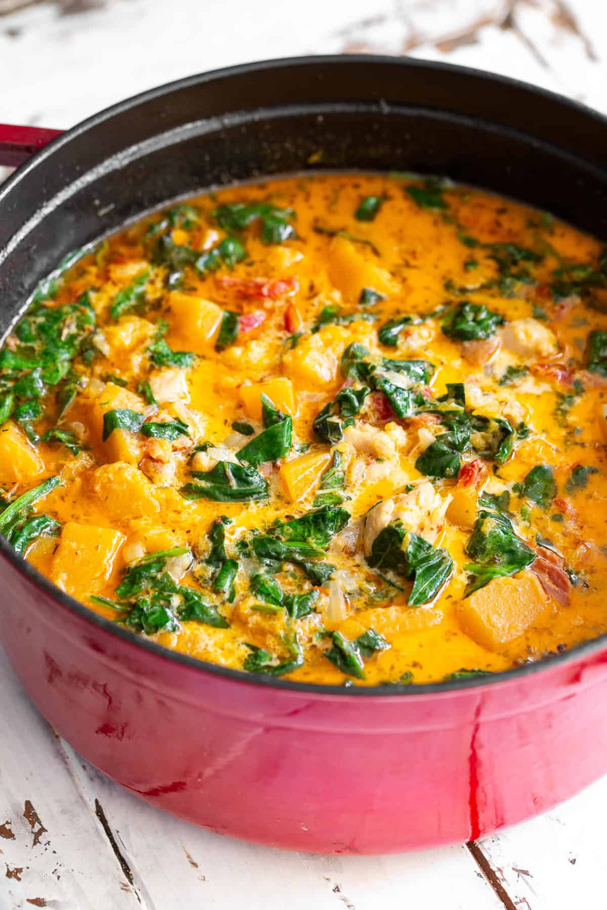 creamy tuscan chicken butternut squash soup in a red dutch oven